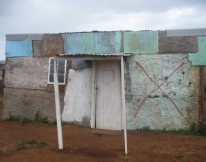 When the government builds new homes, some shacks have to be moved. The government makes markings on buildings to show which part of the shack must be destroyed to make room for the new house. - Abongile Hole